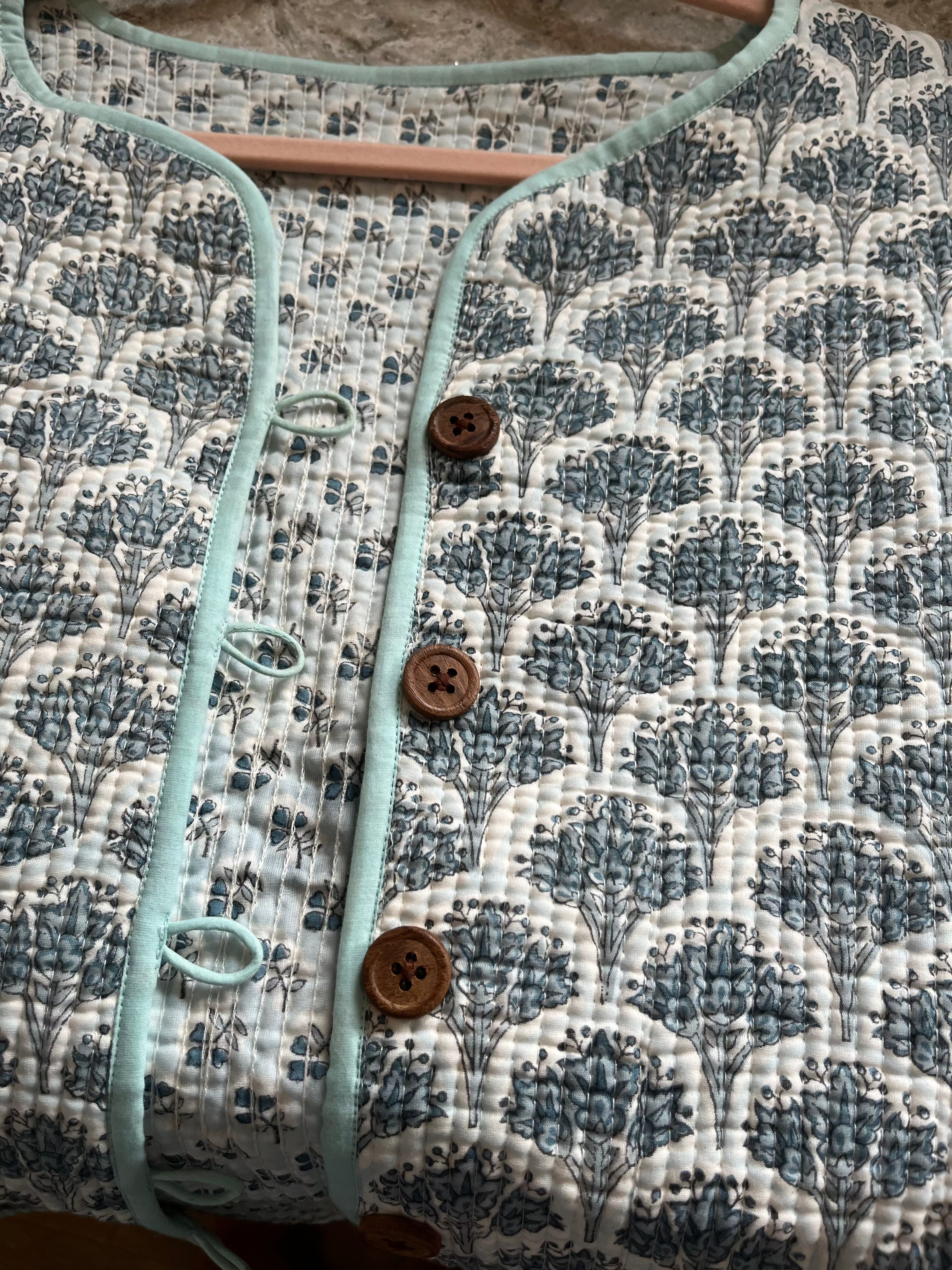 Wood block printed cotton quilted reversible jacket in soft blues.