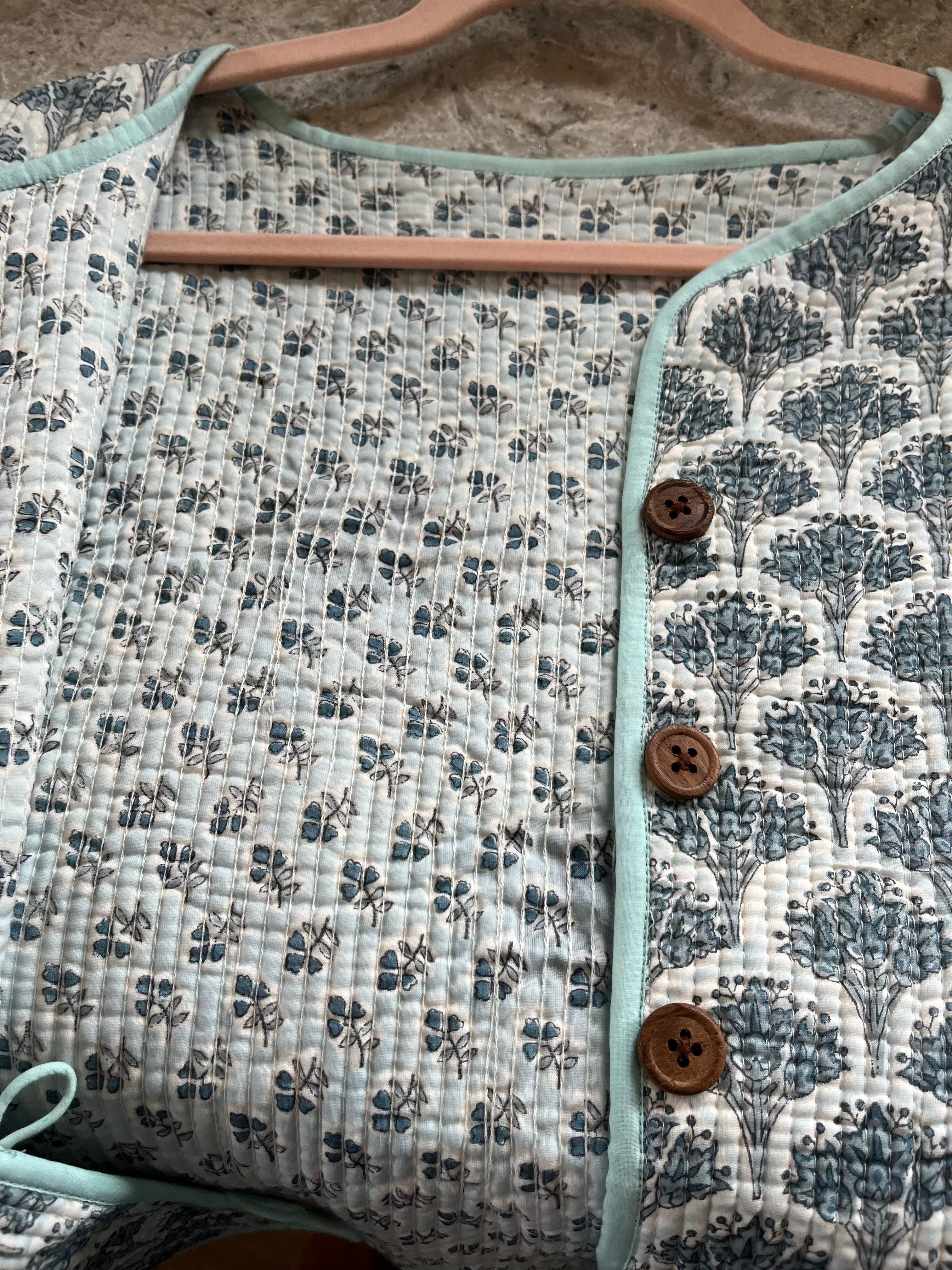 Wood block printed cotton quilted reversible jacket in soft blues.